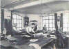 Jack's "rich"uncle's workshop in Bromehead Street where his Barmitzvah suit was made.His uncle is the guv'nor wearing the tie! The lady on the left is his mum making buttonholes[by hand] and the other lady is his aunt, the guv'nor's wife who was filling in for the absent felling hand.